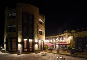 a building with tables and umbrellas at night at Hotel Soli Invicto in Elenovo