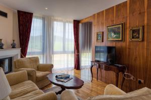 a living room with a couch and a tv at Hotel Soli Invicto in Elenovo