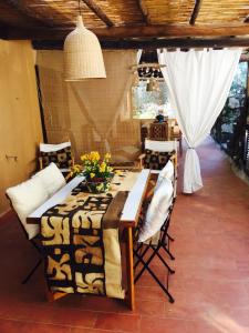 una sala da pranzo con tavolo, sedie e tenda di Le Miniere Apartments a Monte Argentario