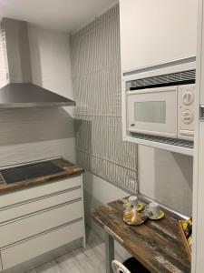 a kitchen with a wooden table and a microwave at ALOJAMIENTO CERRO DEL CABEZO in Andújar