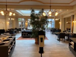 a restaurant with a plant in the middle of a room at Flair Hotel Vier Jahreszeiten in Bad Urach