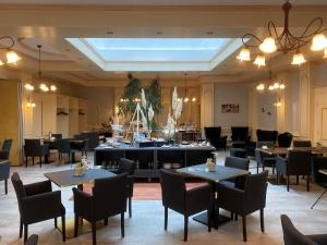 a dining room with tables and chairs and a skylight at Flair Hotel Vier Jahreszeiten in Bad Urach