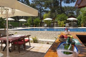a table with a bowl of fruit next to a pool at Koala Bungalows in Olympos