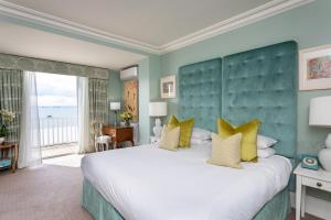 a bedroom with a large white bed with yellow pillows at Roslin Beach Hotel in Southend-on-Sea +37 photos
