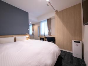 高知市にあるホテルベストプライス高知の白いベッドとデスクが備わるホテルルームです。 +37枚の写真