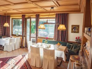 una sala da pranzo con tavoli e sedie bianchi di Bergschlößl a Ramsau am Dachstein