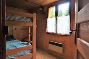 a room with two bunk beds and a window at CHARMIEUX appartement en chalet typique in Le Grand-Bornand