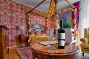 Elenovo的住宿－Hotel Soli Invicto，桌子上放有一瓶葡萄酒和两杯酒
