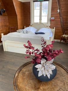 sypialnia z łóżkiem i wazonem z kwiatami na stole w obiekcie Kræmarvika Lodge w mieście Tromsø