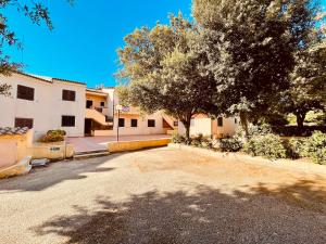a parking lot in front of a house with trees at Appartamento A un passo dal mare in Porto Pozzo