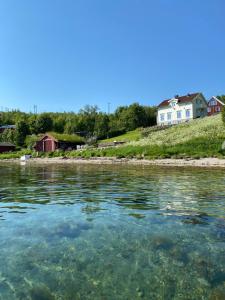 a body of water with houses in the background at Kræmarvika Lodge in Tromsø