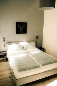 a white bed in a room with a wall at Oskars Absteige in Leipzig