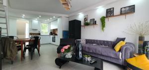 un salon avec un canapé violet et une table dans l'établissement claire, à Camiers