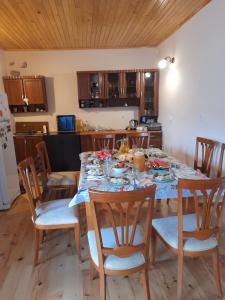 uma cozinha com uma mesa de jantar com cadeiras e uma mesa; em Guest house Lekhtagi em Mestia