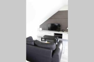 a living room with a couch and a tv at The Loft , Portrush in Portrush