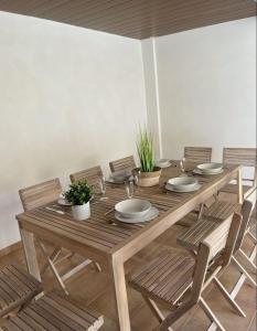una mesa de madera con sillas y platos. en UIM Mediterraneo Columbretes 1 Wifi, en Puerto Sagunto
