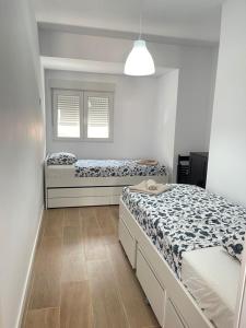1 dormitorio con 2 camas y ventana en UIM Mediterraneo Columbretes 1 Wifi, en Puerto Sagunto