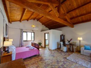 una camera con letto rosa e soffitti in legno di Masseria Crocco a Montalbano Ionico