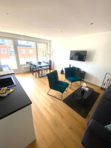 ein Wohnzimmer mit einer Couch und Stühlen und einem Tisch in der Unterkunft Ferienwohnung 3-Zimmer, 70 qm 3 Minuten zum Strand und Zentrum WHG Timme 3 in Timmendorfer Strand