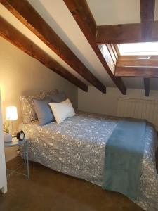 a bedroom with a bed in a room with wooden ceilings at La Buhardilla in Valladolid