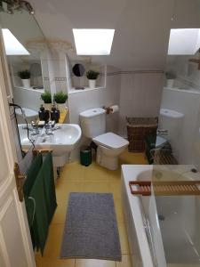 a bathroom with a sink and a toilet and a tub at La Buhardilla in Valladolid
