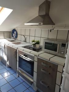 a kitchen with a stove and a microwave at La Buhardilla in Valladolid