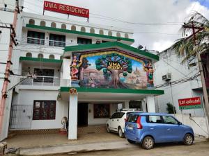 a building with a mural on the side of it at Temple stay - Uma Residency and Guest House in Mayiladuthurai