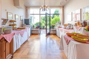 a buffet line with tables with pink table cloths at Hotel Alte Post in Krefeld