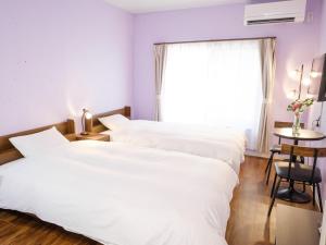 two beds in a room with a window at Hotel Shion no Umi - Vacation STAY 13823v in Miyako Island