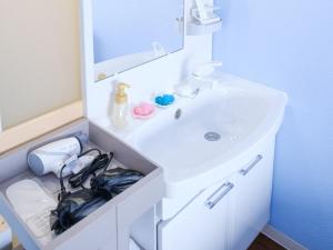 Baño blanco con lavabo y espejo en Hotel Shion no Umi - Vacation STAY 98886, en Isla Miyako