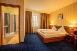 a hotel room with a bed and a bathroom at Business Hotel Vega Wrocław in Wrocław