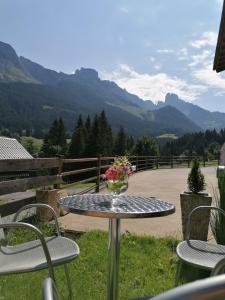 a table and chairs with a vase of flowers on it at Ferienwohnung Donnerkogel in Annaberg im Lammertal