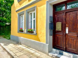 Casa con puerta de madera y 2 ventanas con flores en RiversideSuite. Krakow, en Cracovia