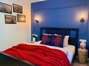 1 dormitorio azul con 1 cama con manta roja en RiversideSuite. Krakow, en Cracovia