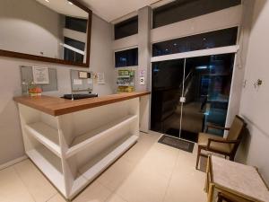 cocina con encimera, mesa y ventana en Rigs Hotel, en São José dos Campos
