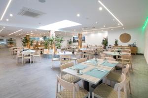 a restaurant with tables and chairs in a room at Hotel Levante in Es Pujols