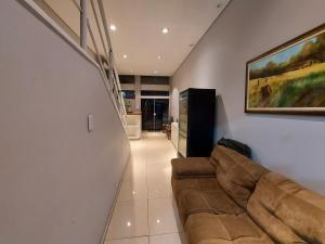 una sala de estar con sofá y una pintura en la pared en Rigs Hotel, en São José dos Campos