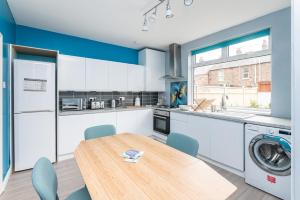 a kitchen with a wooden table and blue walls at Cosy Home with York Minster Views - Pass the Keys in York