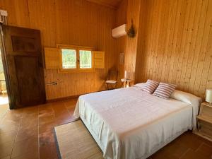 里奥帕尔Casa Rural El Carrizal的一间木屋里有一张床的卧室