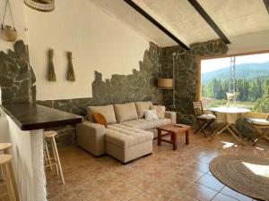 sala de estar con sofá y pared de piedra en Casa Rural El Carrizal, en Riópar