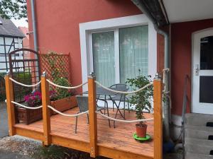 eine Holzterrasse mit einem Seil und einem Stuhl darauf in der Unterkunft Appartment Hochpaterre in Springe