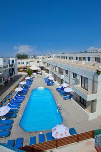 a pool with lounge chairs and umbrellas on a hotel at Paloma Hotel Apartments in Ayia Napa