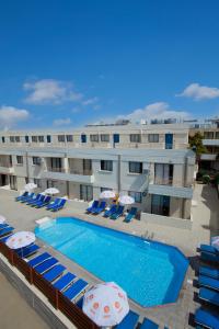 a hotel with a swimming pool with chairs and umbrellas at Paloma Hotel Apartments in Ayia Napa