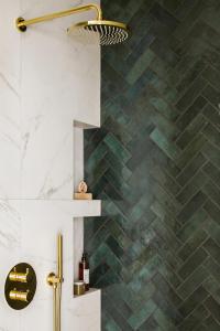 a bathroom with a green tiled wall at Flav Apartment in Kraków