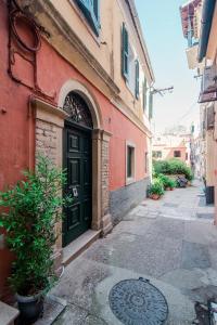 a building with a green door on a street at Curcumelli Luxury Suites - ΚΟΡΚΥΡΑ in Corfu Town