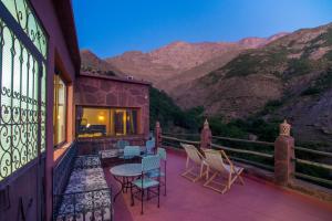 a balcony with chairs and a table and mountains at Kasbah Imlil in Imlil
