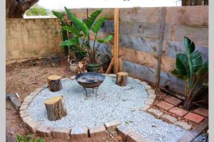 a small garden with a fire pit in the yard at The Homestead - Simple Farm-Style Accommodation in Port Alfred