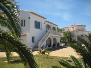 a large white house with a palm tree at Arp in Jávea