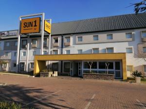 un grande edificio con un cartello di fronte di SUN1 WITBANK a Witbank