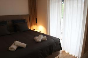 two towels on a black bed with a window at W Apartman in Vrnjačka Banja